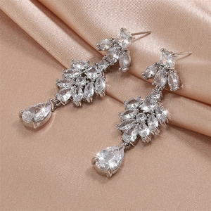 Elegant silver tassel earrings with sparkling white zircons on champagne silk fabric