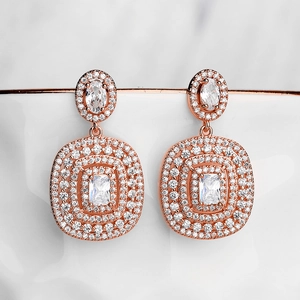 Detailed close-up of rose gold drop earrings encrusted with sparkling zircon stones