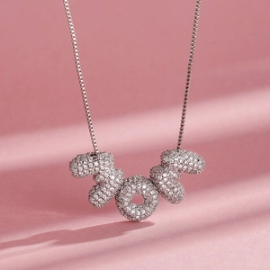 Vue macro du collier avec pendentif MOM serti de zircons blancs étincelants