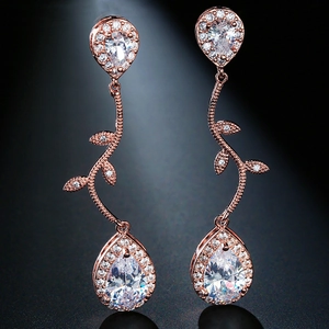 Detail of rose gold tassel earrings featuring pear-cut zircon and crystal vine design