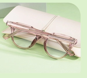 Détail de lunettes de soleil ovales mauves avec branches texture bois et étui cuir