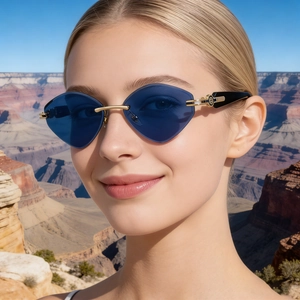 Gros plan de lunettes de soleil œil-de-chat sans monture bleu dégradé avec strass brillants