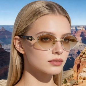 Gros plan de lunettes sans monture dégradées avec détails dorés en C et branches écaillées