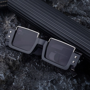 Futuristic square frame sunglasses for men with silver metal trim on black volcanic rock