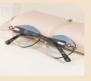 Détail de lunettes de soleil œil de chat, branches camouflage, strass et étui en cuir souple