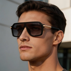 Détail de lunettes de soleil carrées avec accents dorés sur les branches et verres dégradés