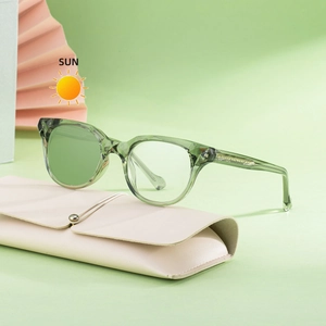 Lunettes de soleil ovales vert transparent avec étui en cuir rose sur fond décoratif