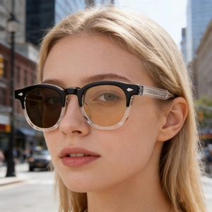Detail of square photochromic sunglasses on model showing lens color transition and rivets