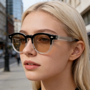 Close-up of dual-tone square sunglasses with metal rivets and transparent temples