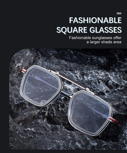 Close-up of square sunglasses featuring double bridge silver frame and gray lenses on rock