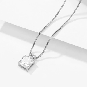 Minimalist silver necklace with princess cut cubic zirconia pendant on white steps