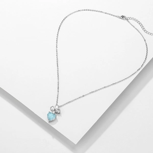 Vue détaillée du pendentif cœur en zircon bleu avec papillon sur chaîne en argent