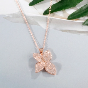 Exquisite rose gold four-leaf clover necklace with pave white zircon on grey background