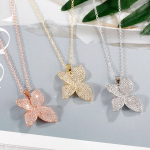 Macro detail of three-tone flower pendant necklaces with sparkling pave zircons
