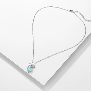 Collier élégant avec pendentif coeur bleu clair sur podium blanc géométrique
