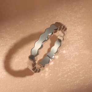 Makroaufnahme eines gewellten Ringbands aus Silber im minimalistischen Geometrie-Design