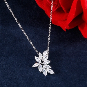 Détail du collier avec pendentif feuille en zircon marquise sur fond en velours bleu