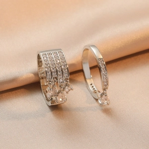 Elegant silver-tone rhinestone ring set with teardrop fringe on champagne silk background