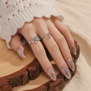 Vintage silver-tone layered rings with teardrop rhinestones and sparkling nail art