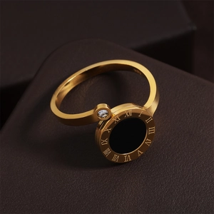 Détail macro d'une bague en acier doré avec chiffres romains et pierre en zircone