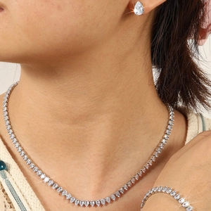Iced out rhinestone teardrop necklace and earrings set worn by a female model