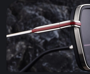 Detailed macro view of square sunglasses with silver metal temples and red accents