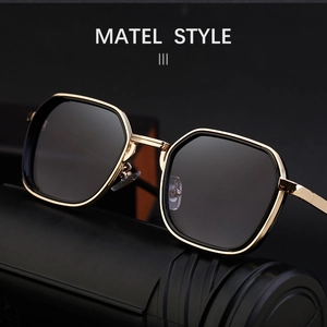 Detail of square gold metal frame sunglasses with dark lenses on a black display stand