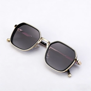 Modern square sunglasses with gold metal frame and dark lenses on a white background