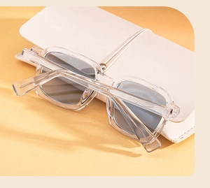 Detail view of square transparent grey sunglasses frame with visible metal wire core in temples