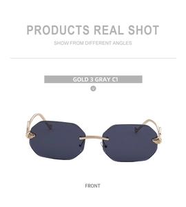 Detail of square rimless sunglasses with gold shell-textured hinges and dark gray lenses