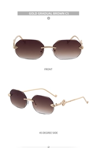 Detail of square rimless sunglasses with gold snake-shaped temples and brown gradient lenses