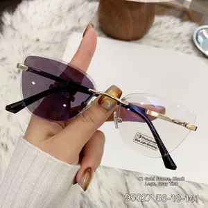 Detail of rimless cat-eye photochromic glasses with golden metal frame and blue light filter