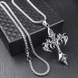 Detail of punk silver stainless steel flame cross pendant with box chain on jewelry box