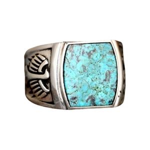 Macro detail of vintage turquoise ring with intricate eagle wing side carvings