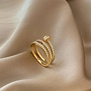 Luxury gold layered nail ring with sparkling pavé zircons on champagne silk fabric