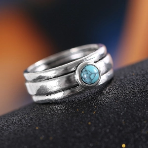 Retro silver ring with turquoise inlay on a matte black stand, detailed vintage design