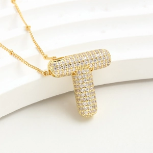 Collana con ciondolo a lettera T dorata con pavé di zirconi lucidi e design a bolla
