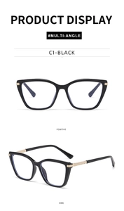 Detail of cat eye glasses with black frames, gold metal temples and rhinestone accents
