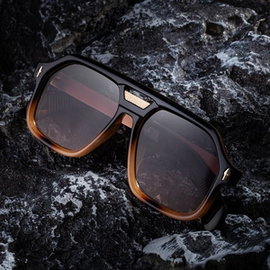 Polarized square sunglasses with gradient frames and gold metal bridge on dark rock