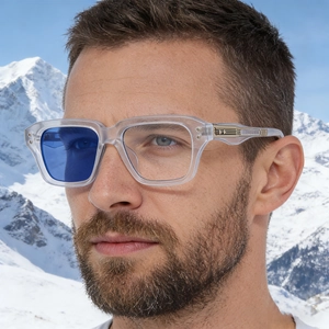 Close-up of square photochromic sunglasses with metal trim against a snowy mountain backdrop