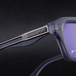 Detailed close-up of sunglasses temples with metal texture and purple reflective lenses