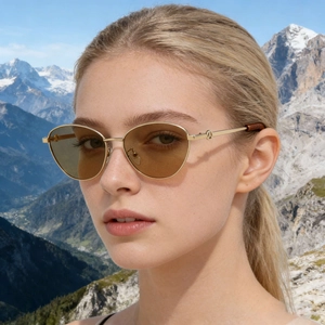 Lunettes de soleil polarisées œil-de-chat avec monture en métal doré et verres marron sur modèle