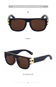 Détail de lunettes de soleil carrées noires avec charnière C dorée et verres marron foncé
