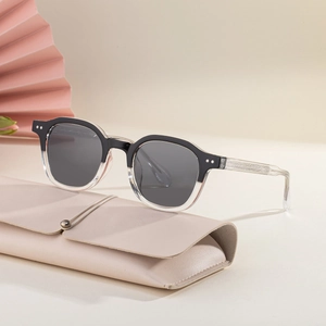 Lunettes de soleil carrées bicolores avec monture noire sur étui en cuir beige