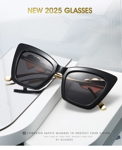 Detail of oversized cat-eye sunglasses featuring gold metal temples and heart-shaped accents