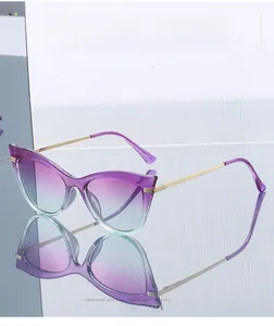Detail of golden textured metal temples and purple gradient lenses on cat eye sunglasses