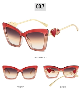 Detail view of cat eye sunglasses featuring heart-shaped metal accents and gradient lenses