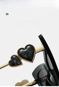 Macro detail of golden metal temple with marble heart accents on cat eye sunglasses