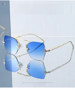 Close-up of rimless polygon sunglasses with blue gradient lenses and gold engraved temples