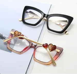 Detail of cat eye glasses frames with gold temples and decorative heart accents